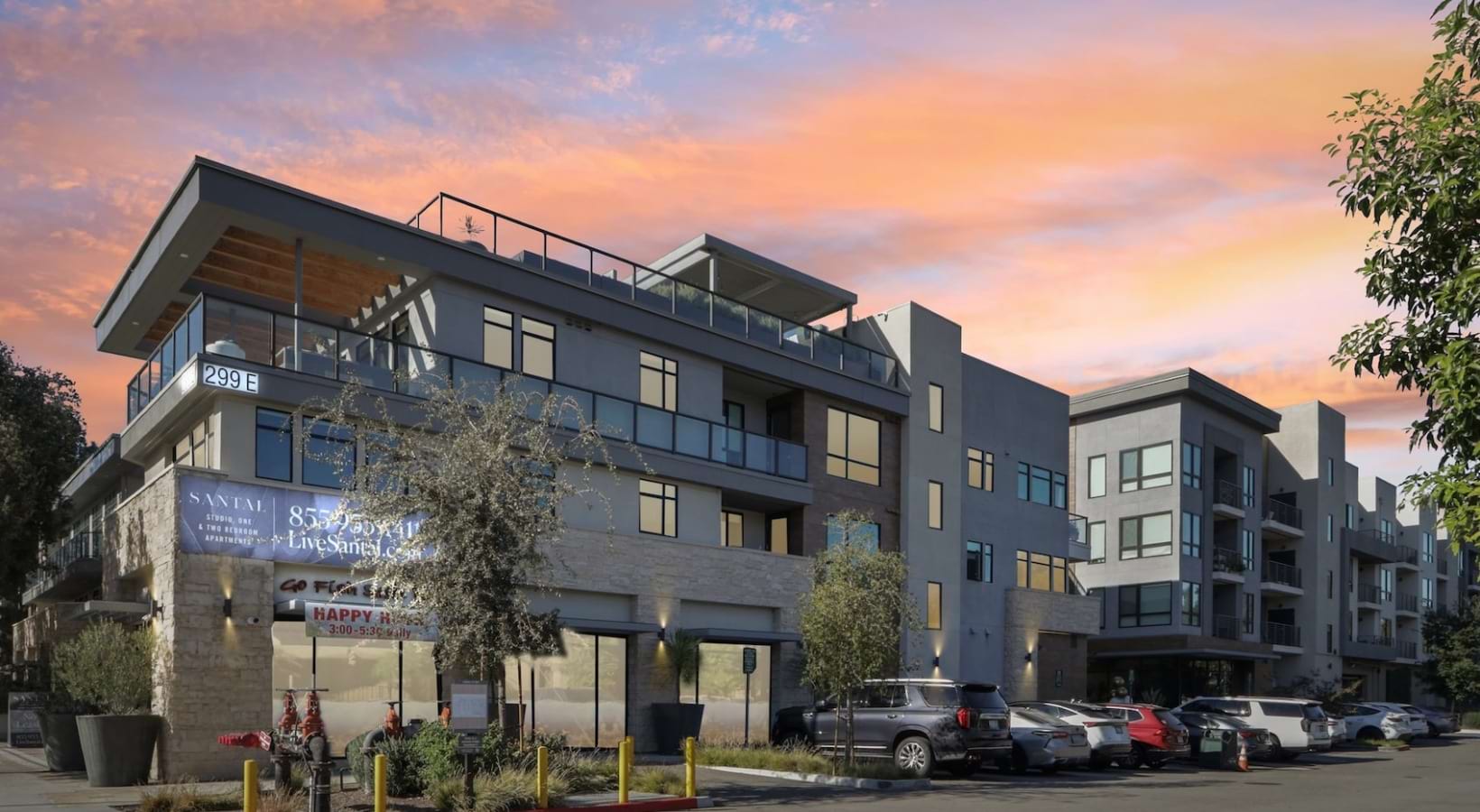 A sunset exterior shows modern balconies, street-level retail, and LiveSantal.com signage on the Santal Thousand Oaks building.